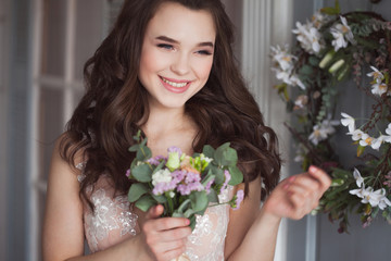 lovely young woman brunette n a Lacy pink dress. Attractive bride with a bouquet of flowers