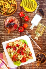 Pasta salad with cheese. Summer salad. Diet Diet. Pasta with vegetables on wooden table.