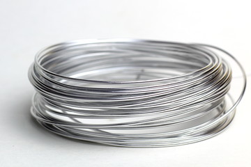 Coil of silver wire on a light background.