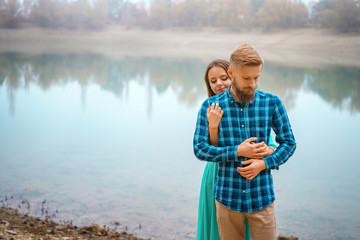 a guy with a girl standing at the lake in an embrace. romantic relation