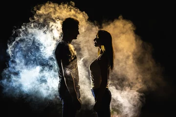 Fotobehang The silhouette of man and woman in the smoke © realstock1
