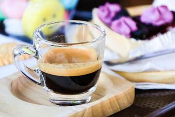 Cup of espresso coffee  on wooden plate in morning time.