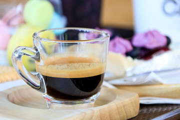 Cup of espresso coffee  on wooden plate in morning time.