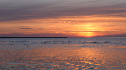 Beautiful fiery sunset sky on the beach. Composition of nature, Waves of the sea on a sandy beach.