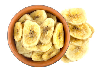 Banana chips in bowl on white background