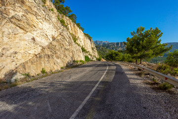 Empty road in mountainous area along  mountains and pine trees. Scenic driveway in Turkey. Horizontal color photography.