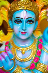 Closeup Portrait of  Hindu God Krishna in colorful high glossy statue.