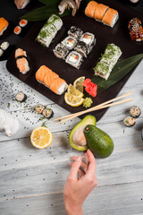 Fototapeta na wymiar Sushi set with salmon, eel, tuna, avocado, cream cheese Philadelphia, caviar, chuka. Sushi menu. Japanese food on black and white background