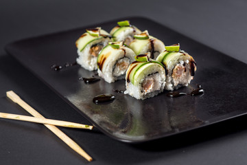 Japanese sushi with avocado on black background