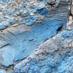 The texture of the old stone wall painted blue