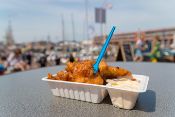 delicious fried kibbling fish and sauce at Scheveningen harbor cafe in the Netherlands on warm sunny day
