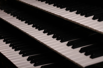 Three rows of pipe organ piano keyboard, closeup view, shallow depth of field