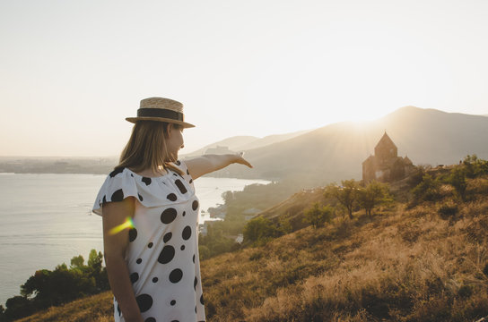 young woman tourist lokking forwart to Sevan monastery in Armenia