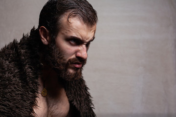 Bearded, brutal man on a plain background. Viking (barbarian).