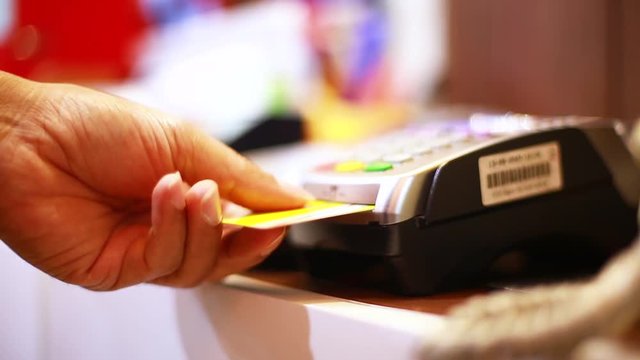 Hand put credit card In slot of credit card reader and press the button, credit card payment, buy and sell products & service, the concept of payment without cash, slow motion and selective focus.