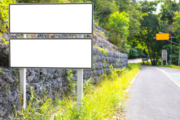 white color blank billboard or road sign on the road near green wood