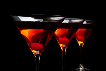 Close-up manhattan drinks with red cherry on black board