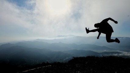 silhouette of man jumping against sky