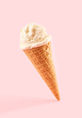 White ice cream ball in a Waffle Cone on a pink Background. Fruit ice cream in a waffle cone.