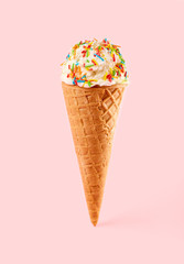 White ice cream ball in a Waffle Cone on a pink Background. Fruit ice cream in a waffle cone.