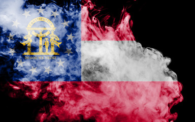 The national flag of the US state Georgia in against a gray smoke on the day of independence in different colors of blue red and yellow. Political and religious disputes, customs and delivery.