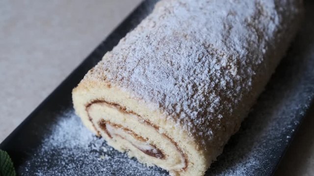 chef sprinkled with powdered sugar swiss ​​roll.