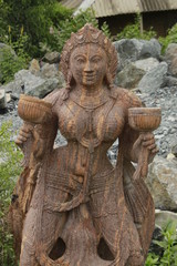 Beautiful/perfect sculpture of Dancing devadasi Holding musical instrument on her hand carved from red sand stone with natural background.An female servant of god or jogini is a girl.