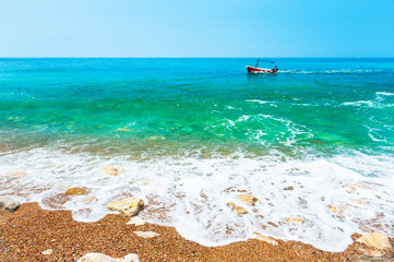 Fototapeta na wymiar Beautiful beach with turquoise water and boat on the sea shore. Adriatic sea, Montenegro.