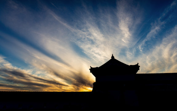 Silhouette scene of old building with dramatic sky at sunset