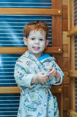 cute boy in bathrobe sitting in the sauna