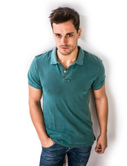 Fototapeta premium Handsome young man in green shirt and jeans posing isolated on white background in studio,