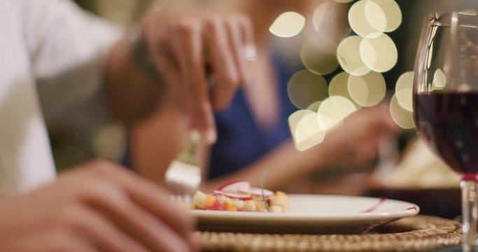 Man hands detail while eating using fork during a romantic gourmet dinner or lunch.Wide shot. Friends italian trip in Umbria.4k slow motion