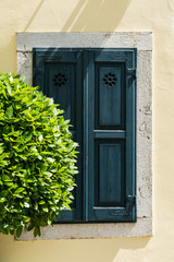 Fototapeta na wymiar closed blue green wooden shutters, concrete wall. Opaija, croatia