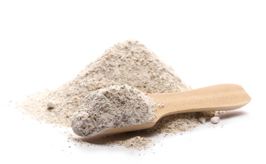 Integral rye flour pile in wooden spoon isolated on white background