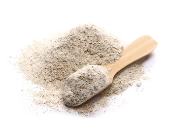 Integral rye flour pile in wooden spoon isolated on white background