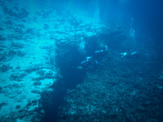 Fototapeta na wymiar Dahab, Egypt - November 4, 2012. Scuba divers exploring crack in sea bottom in Red Sea, Egypt, Dahab