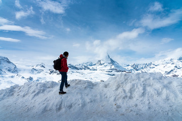 Naklejka na ściany i meble Man in red jacket is looking Matterhorn peak on Gornergrat peak, Zermatt, Switzerland