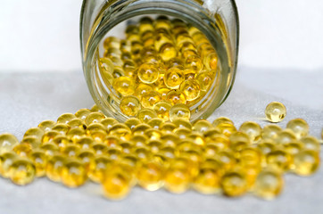 fish oil in omega-3 round capsules on a white background. copy space, soft focus.