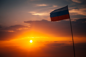 the setting sun beautifully illuminates the flag of the Russian Federation