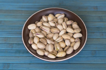 Healthy food  for background image close up pistachios nuts. Texture on top view Nuts pistachio on the cup plate