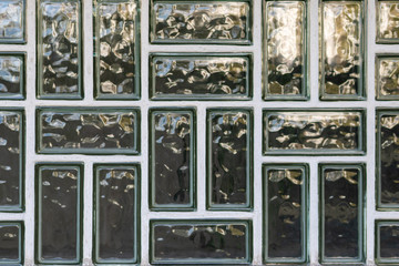 Wand aus Glasbausteinen mit weißen Fugen und schön geschwungener Oberfläche als moderner Hintergrund