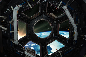 Fascinating sunrise on earth. Spaceship window view. Elements of this image furnished by NASA.