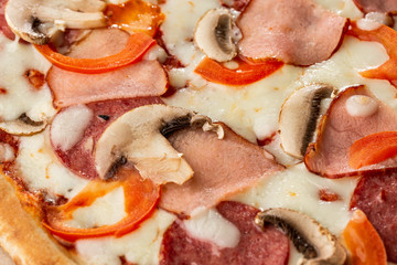 Fototapeta na wymiar Top view of delicious Capricciosa Pizza on wooden table. Ingredients peeled tomato, cheese, ham, mushrooms, salami.