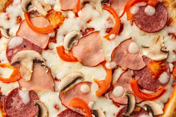 Top view of delicious Capricciosa Pizza on wooden table. Ingredients peeled tomato, cheese, ham, mushrooms, salami.
