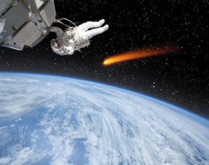 Astronaut over the earth, comet flying near. The elements of this image furnished by NASA.