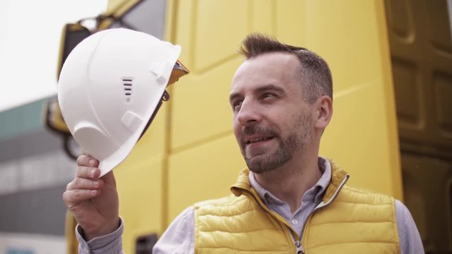 Trailer driver with hard hat and safety vest. Close up portrait of worker