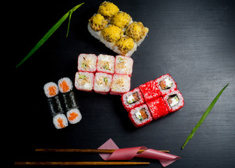 Obraz na płótnie Canvas Japanese sushi and rolls on a black background