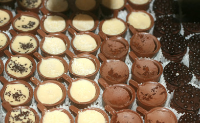 Chocolates with nuts. Texture of candy. Confectionery.