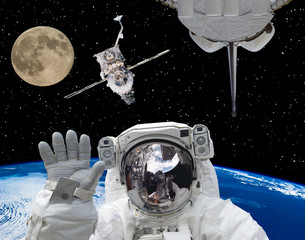 Astronaut in outer space, moon and spaceships on the backdrop. The elements of this image furnished...