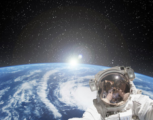 Astronaut makes selfie against sunrise. The elements of this image furnished by NASA.